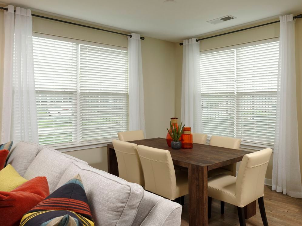 Living and dinging area with carpeted flooring, and open concept kitchen with white shaker cabinetry and hard surface flooring