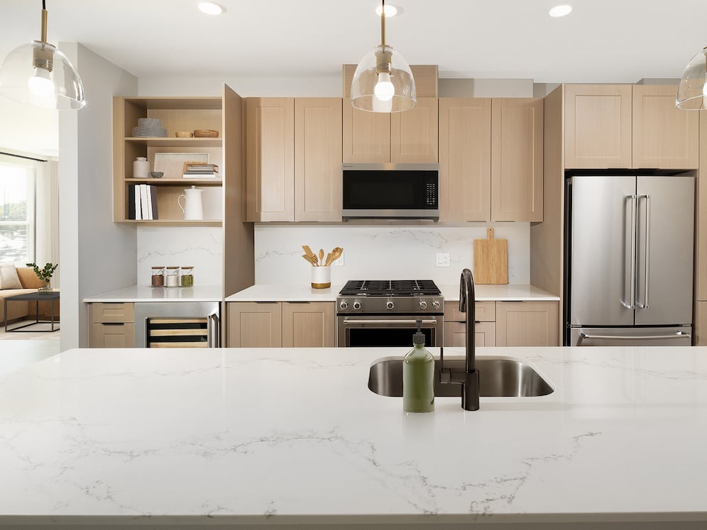 Signature Collection Kitchen with oak shaker cabinetry, marbled white quartz countertop and backsplash, and upgraded stainless steel appliances