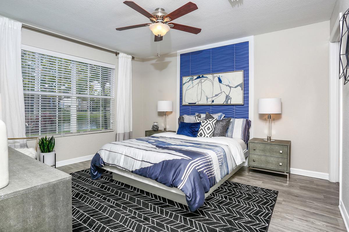 Master bedrooms featuring wood-style flooring, a walk-in closet, and a ceiling fan.