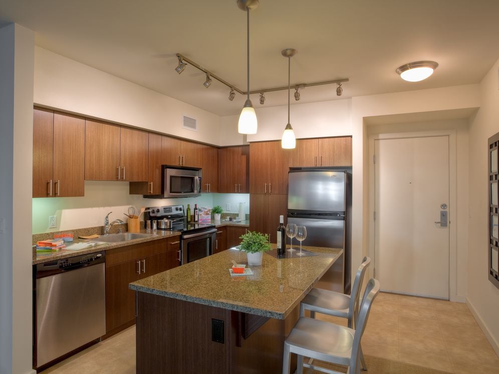 Classic Package I kitchen with brown speckled granite countertops, espresso cabinetry, stainless steel appliances, and hard surface flooring