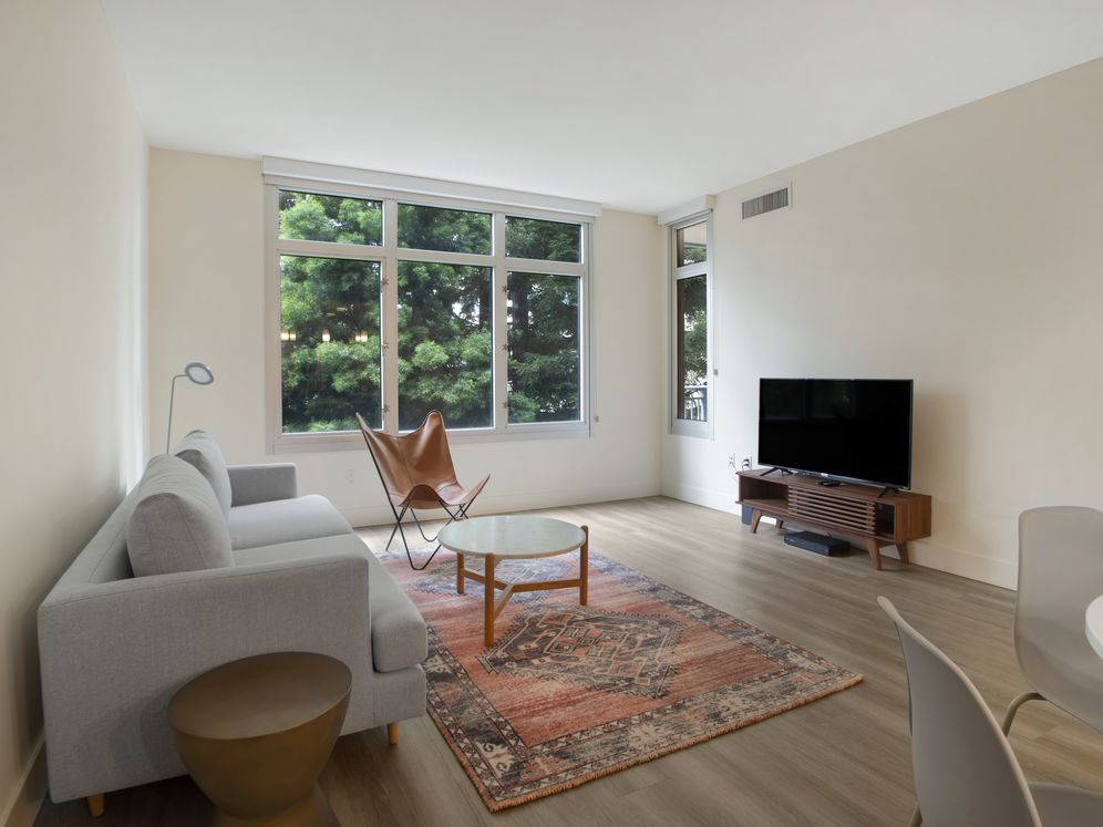 Furnished+ apartment homes come outfitted with a sofa, side chair, side table, coffee table, TV stand and 50" Television (Representative Image – exact items and style of furnishings may vary)