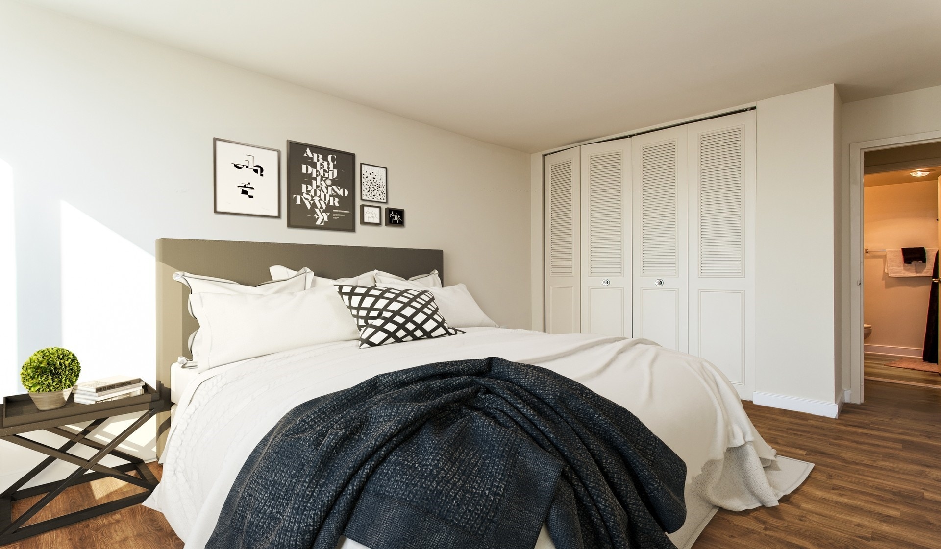 Bedroom features wood plank flooring and a large closet