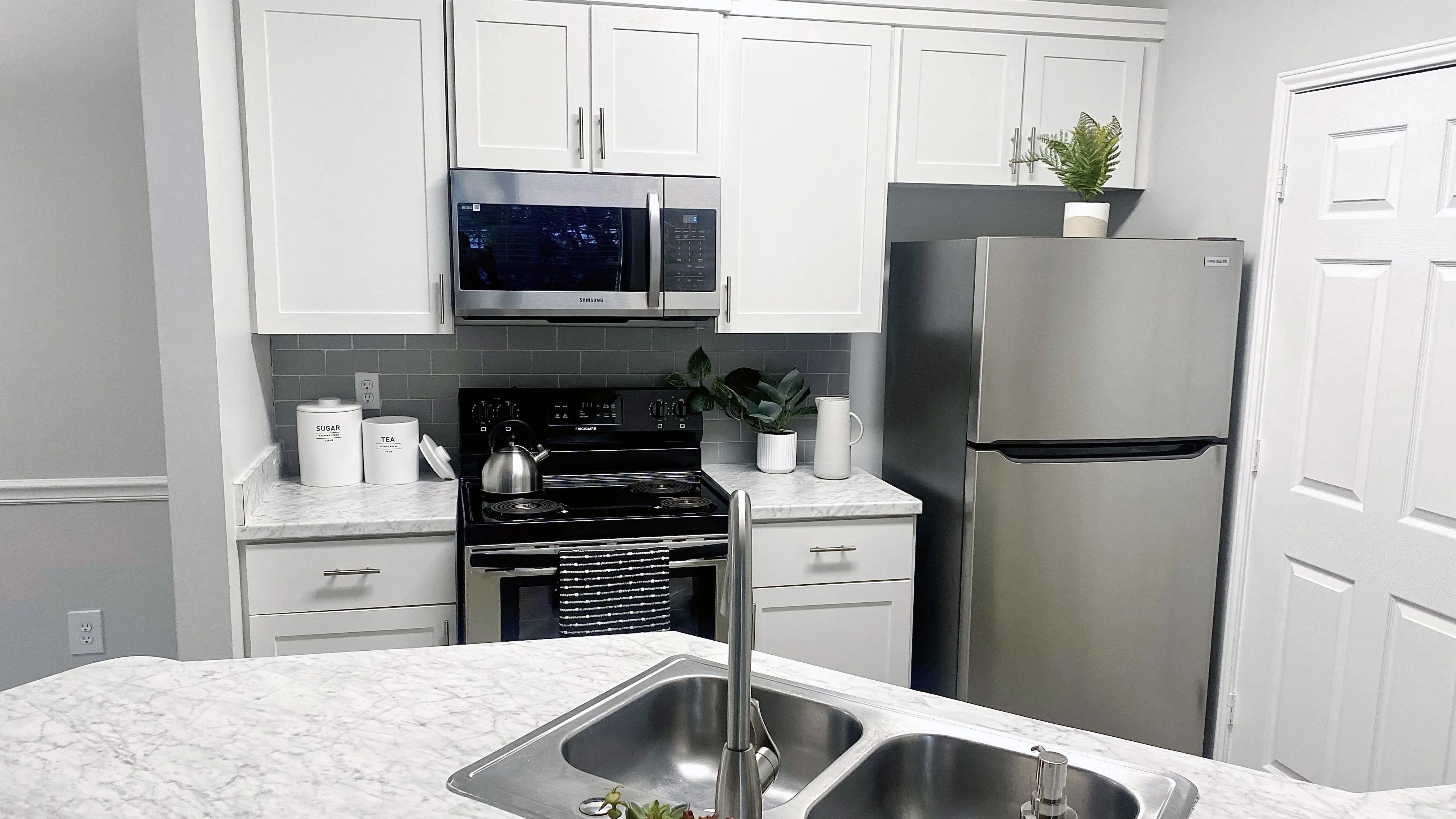 White cabinetry and stainless-steel appliances in our open-concept kitchens are complimented by Carrara marble inspired countertops in select homes.