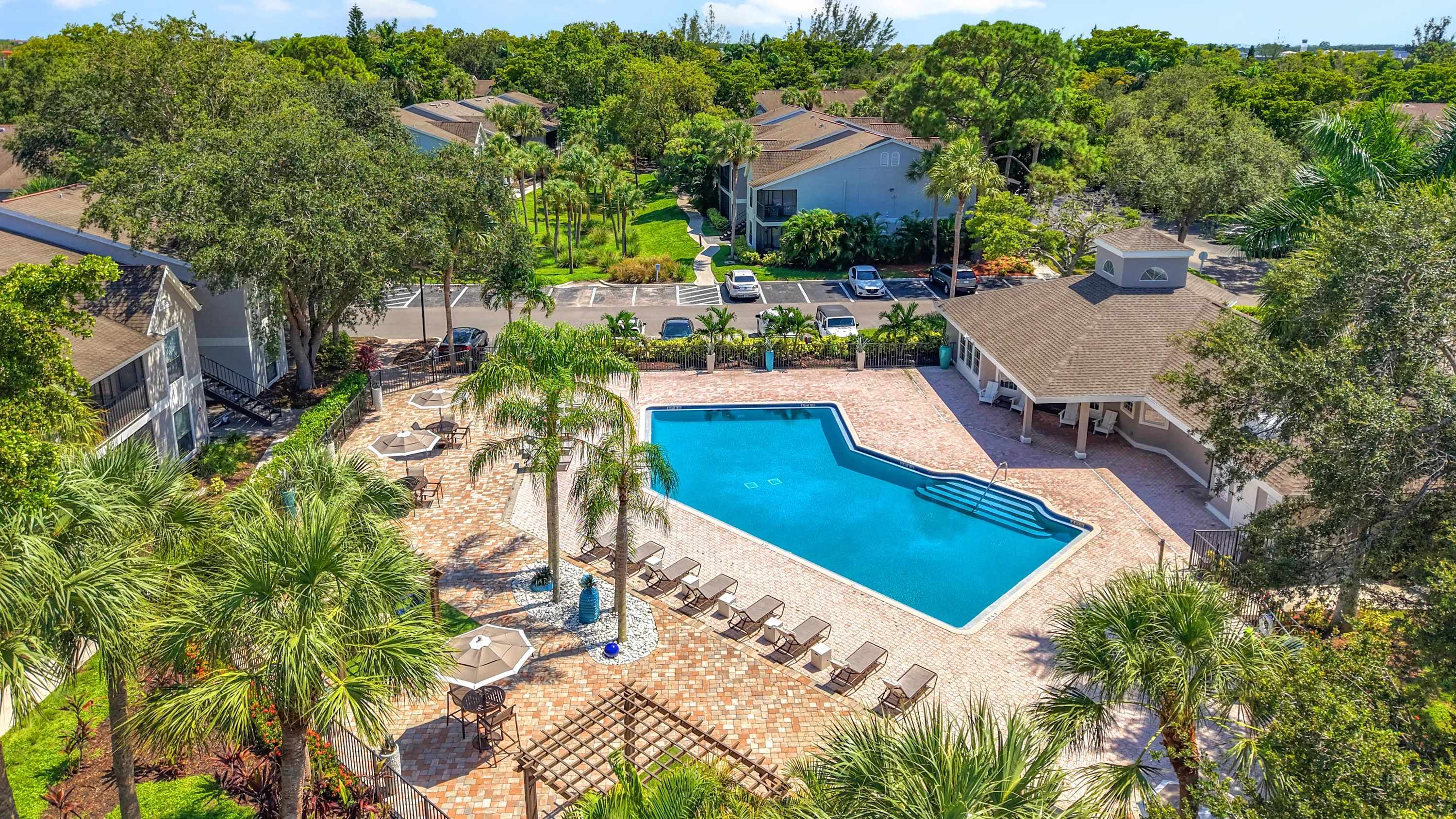 Discover an aerial perspective of River Reach’s inviting amenities—resort-style pool, lounge seating, and lush landscaping in the heart of Naples.