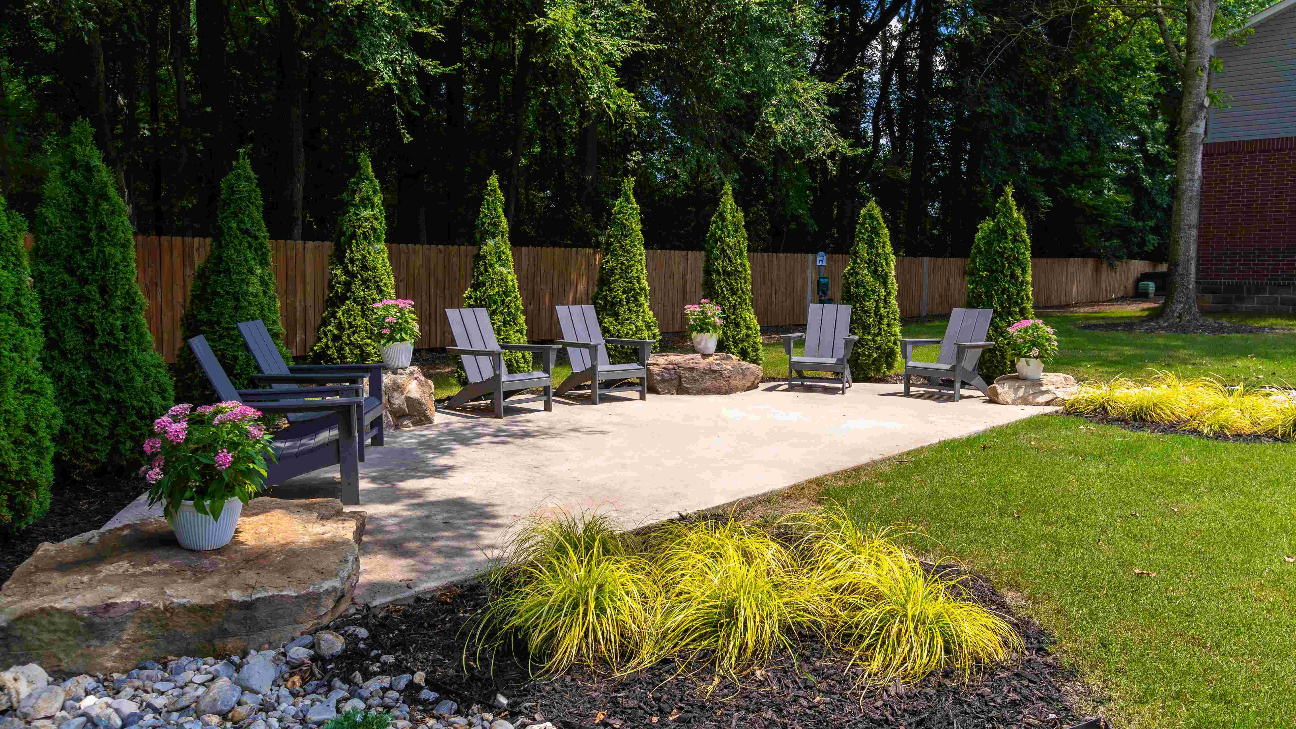 Unwind in the tranquil outdoor seating area surrounded by lush greenery and serene ambiance.