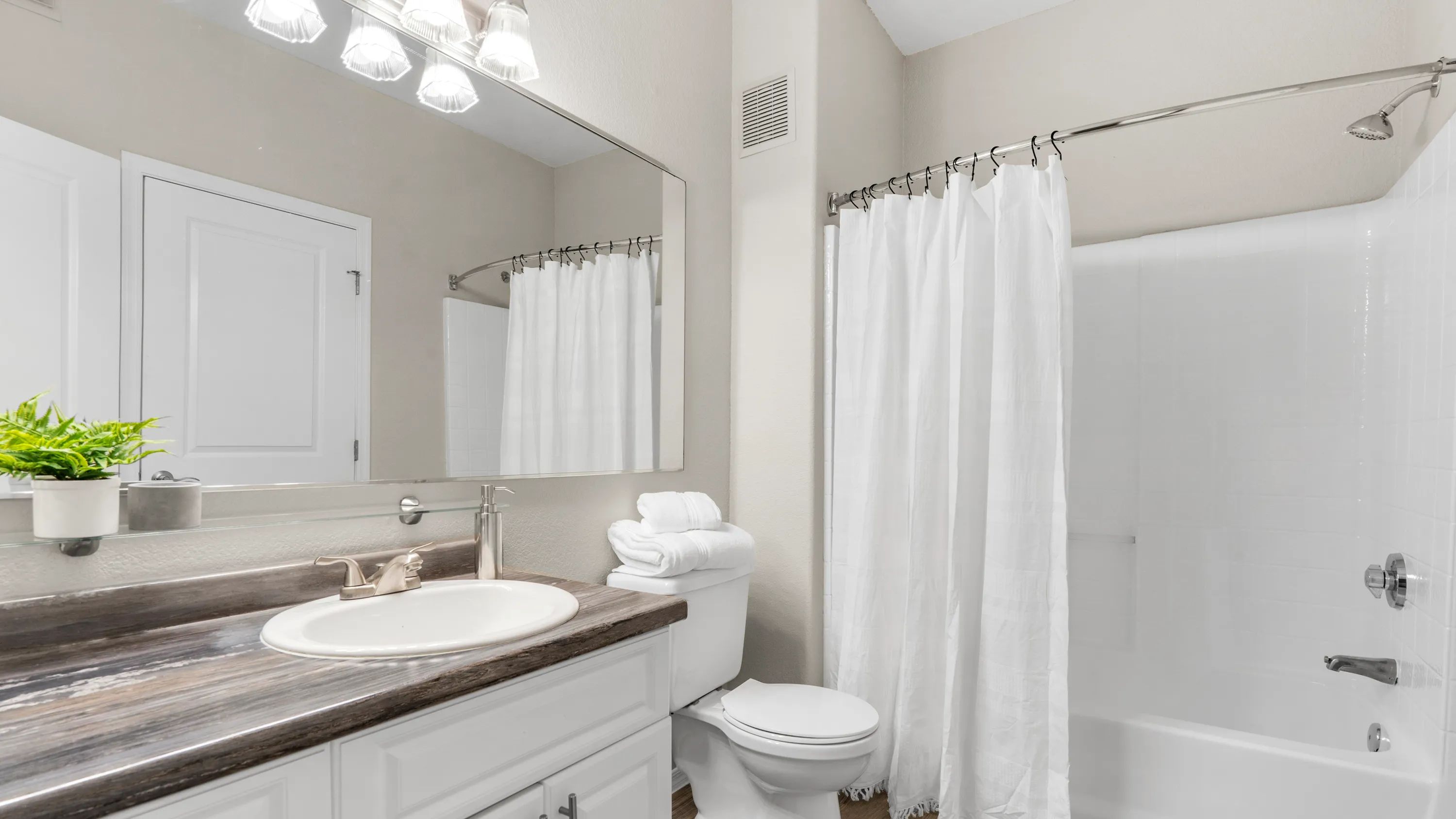 Luxuriate in a bathroom with a spacious, well-lit vanity area. 