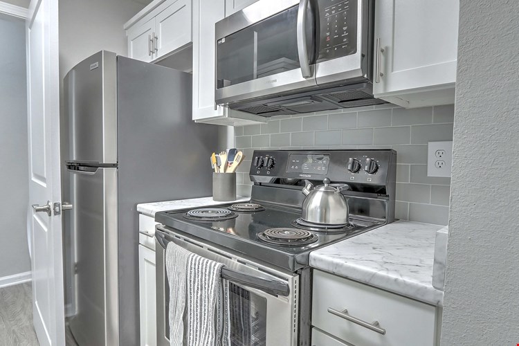 Kitchens with stylish appliances and a hip grey tile backsplash.