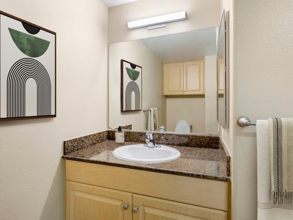 Classic Package II bath with brown speckled granite, oak cabinetry, and hard surface flooring