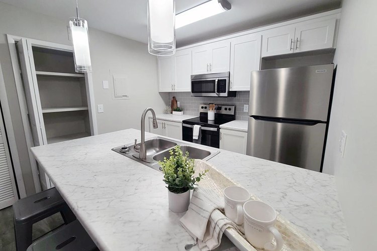 Kitchens feature marble-style countertops, wood-style flooring, an oversized pantry, and stainless steel appliances.