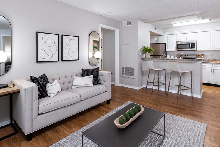 Enjoy the inviting feel of this open-concept living area featuring wood-style flooring, modern finishes, and a seamless flow into the kitchen—perfect for hosting or relaxing.