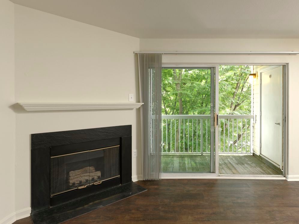 Living area with hard surface flooring, fireplace and balcony