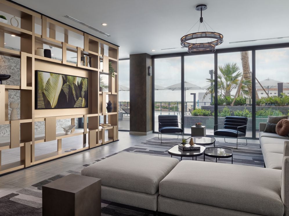 Resident lounge with modern seating and pool deck views