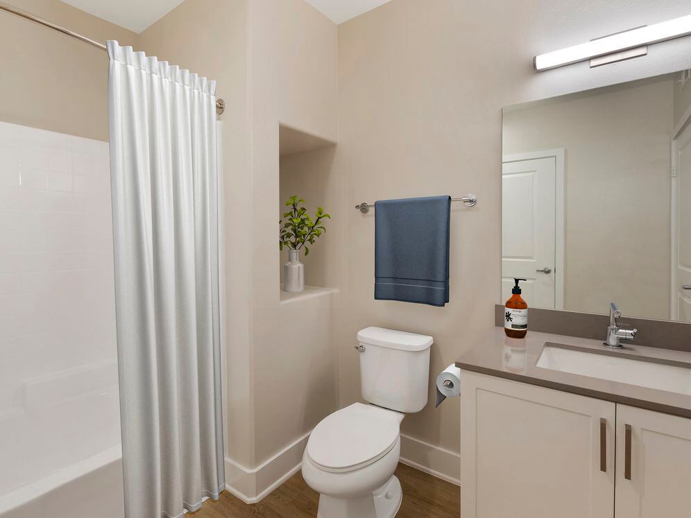 Renovated Package I bath with grey quartz countertops, white cabinetry, and hard surface flooring