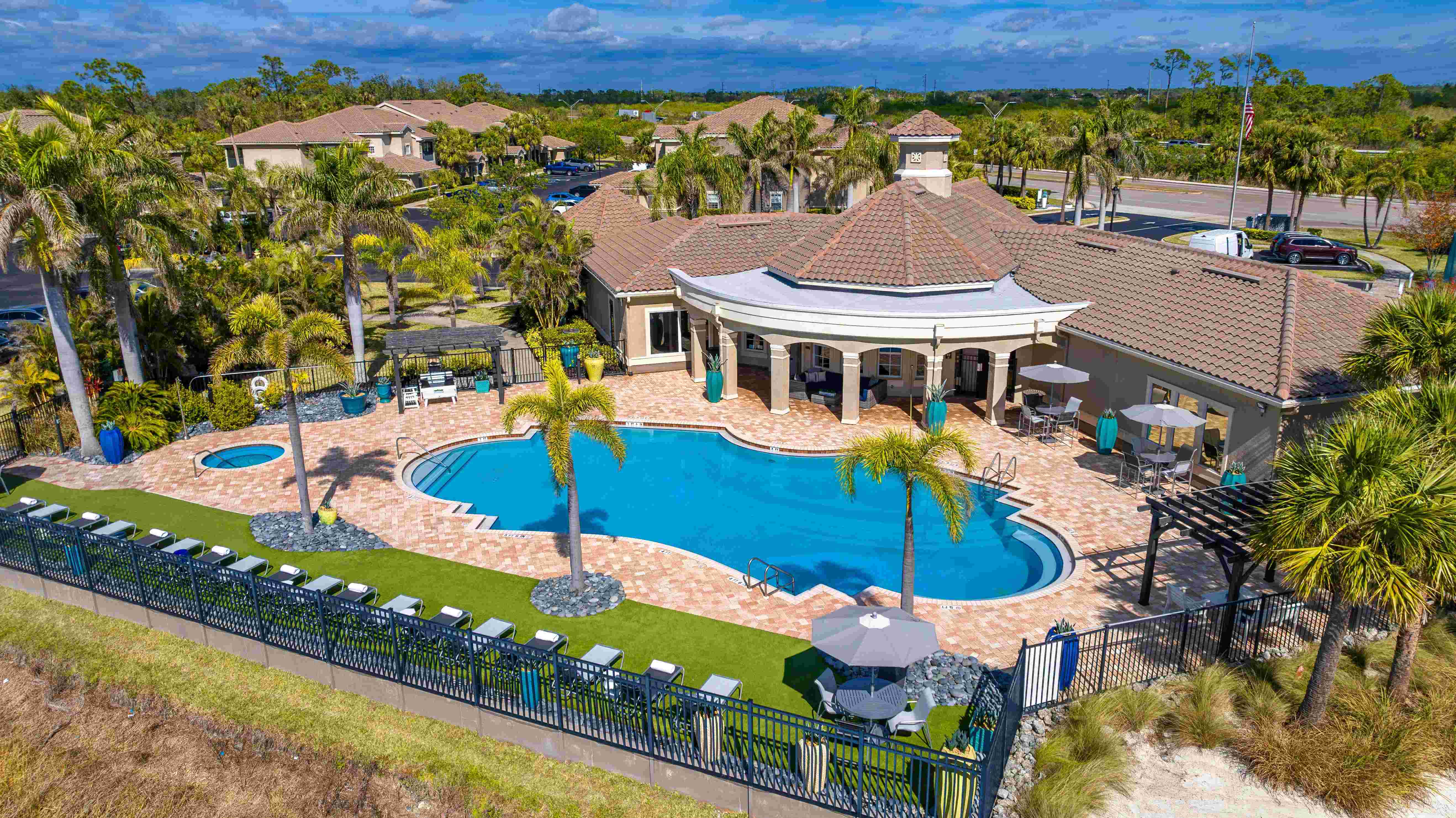 Experience true relaxation with a beautifully designed pool area featuring shaded seating and tropical landscaping.