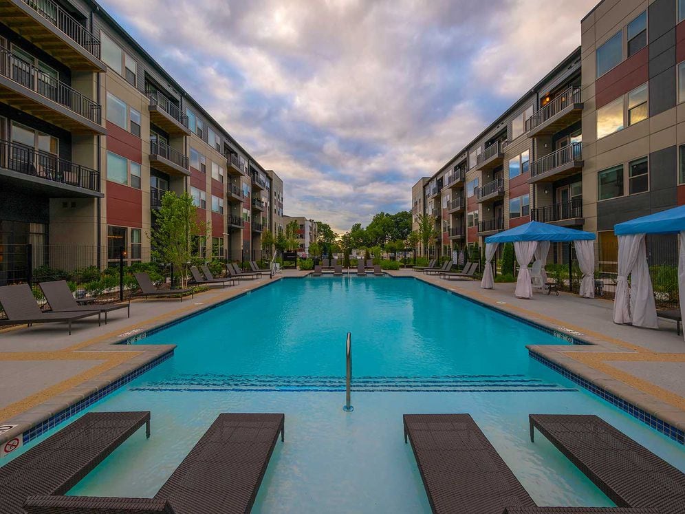 East building swimming pool with sundeck and lounge seating