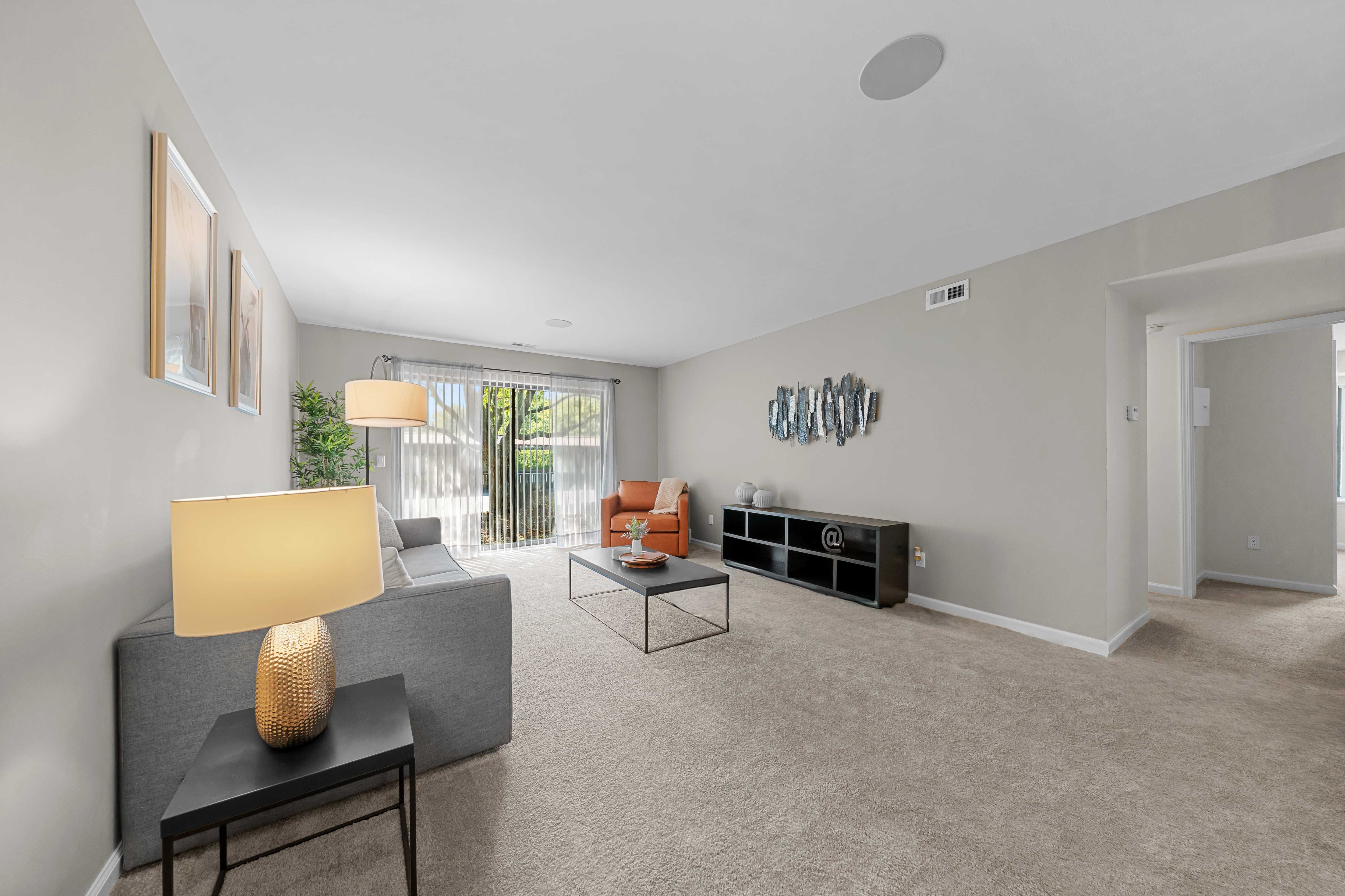 Spacious Living Room with Sliding Glass Door at Lakeside Village Apartments Clinton Township MI