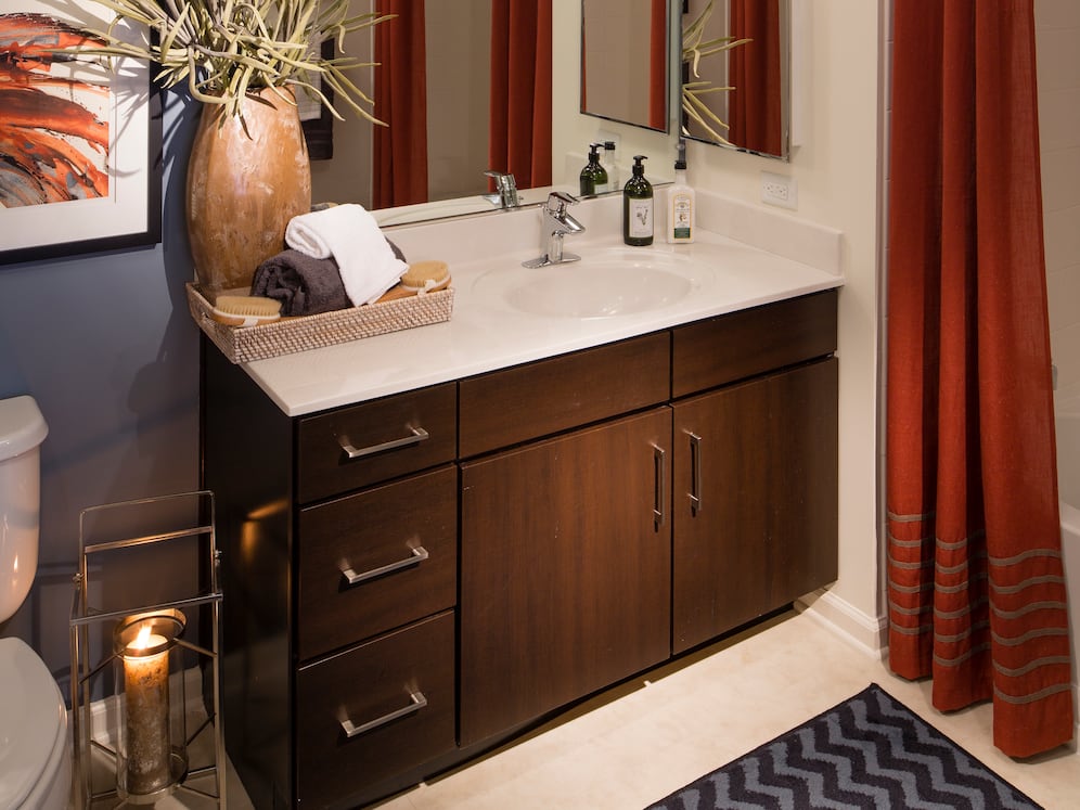 Bath with laminate countertop, espresso cabinetry, and tile flooring