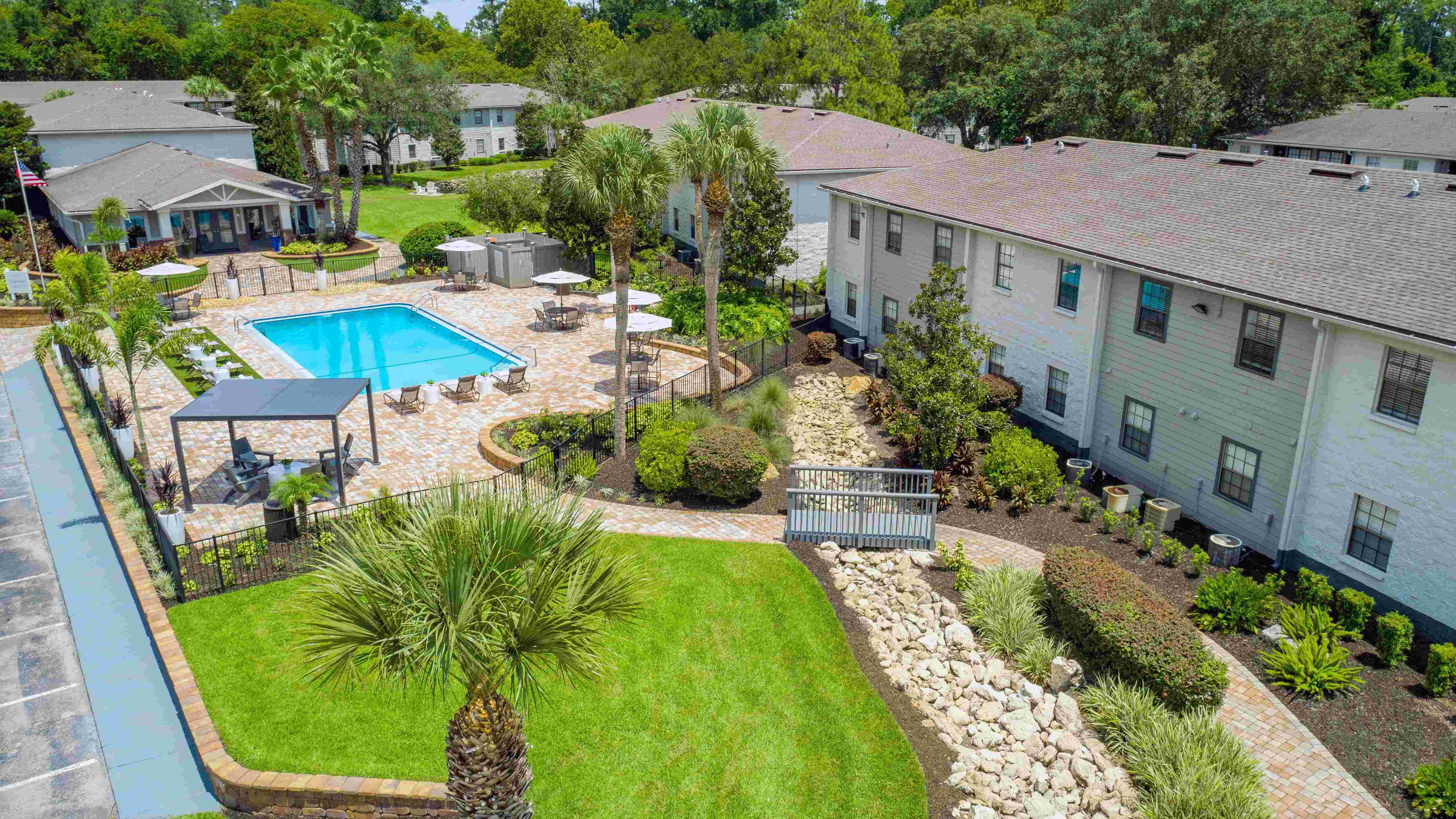 Soar high for a breathtaking view of the resort-style pool, expansive sundeck, and elegantly paved walkway. 
