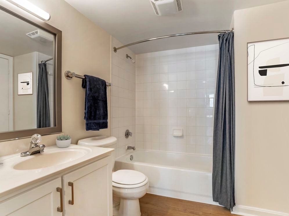 Renovated Package I bath with white cabinetry, granite countertops, and hard surface flooring