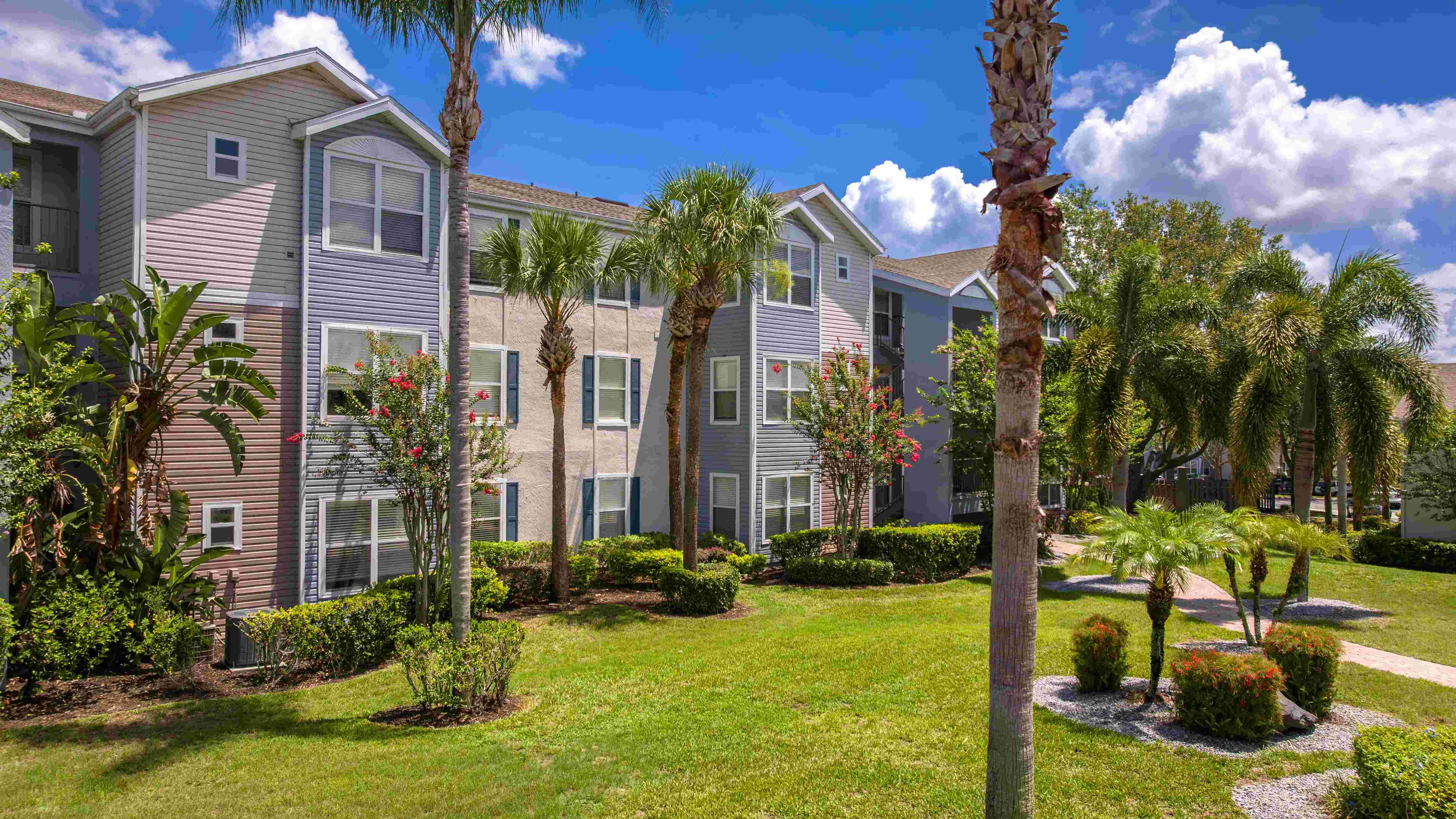 Step outside your door into a tropical oasis—lush greenery, swaying palms, and colorful blooms surround every apartment home.