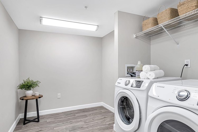 The laundry room is equipped with full-size washer and dryer appliances, and also offers plenty of additional storage space.