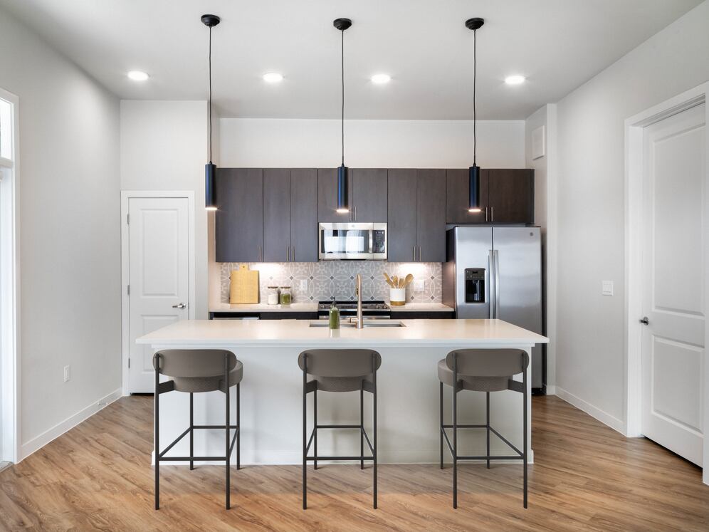 Kitchens with stainless steel appliances, wine fridges, quartz countertops, tile backsplash, and hard surface flooring