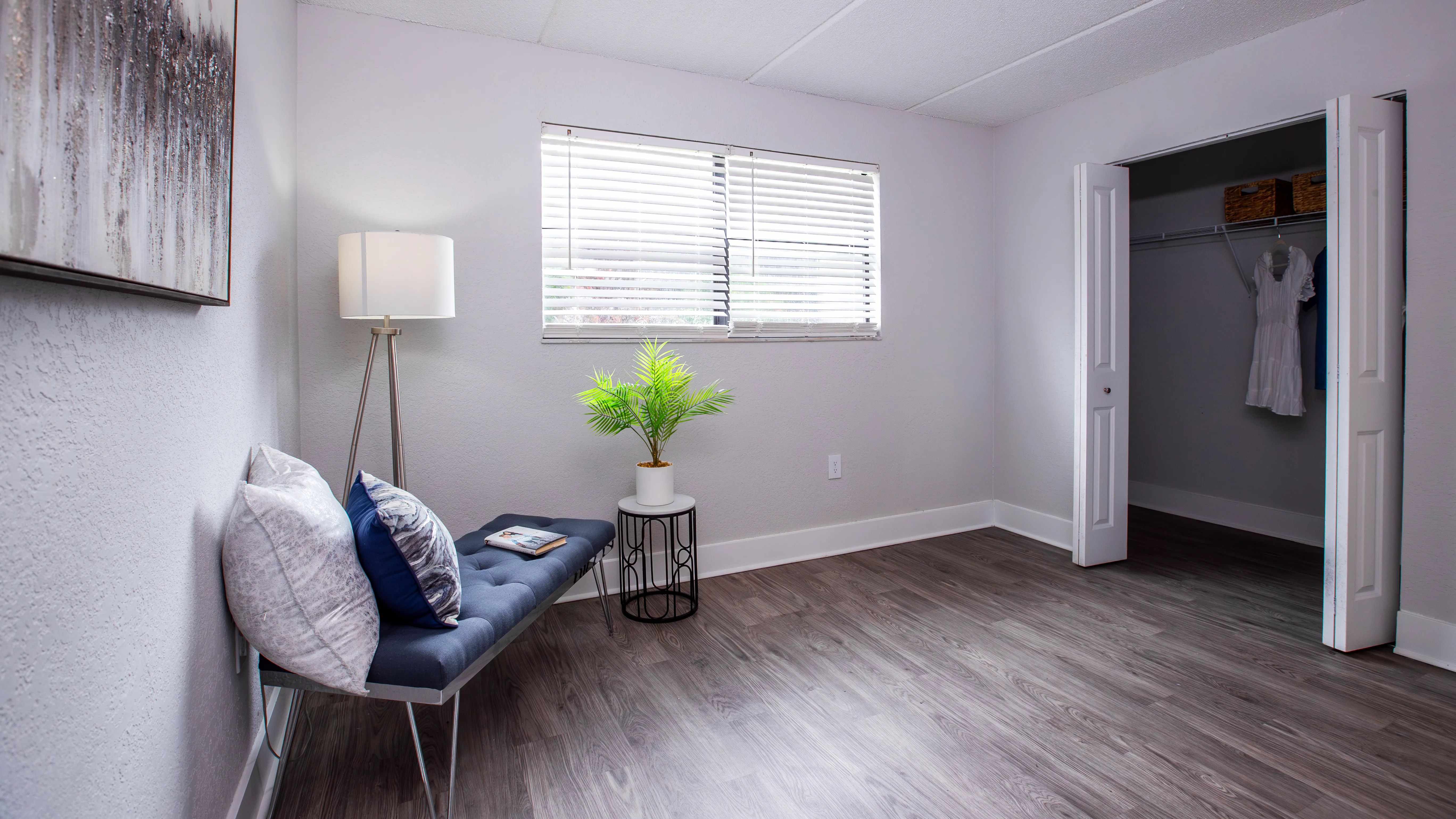 Spacious bedrooms at featuring a large window for natural light, sleek wood-style flooring, and a generously sized closet, offering both style and functionality for your everyday living.