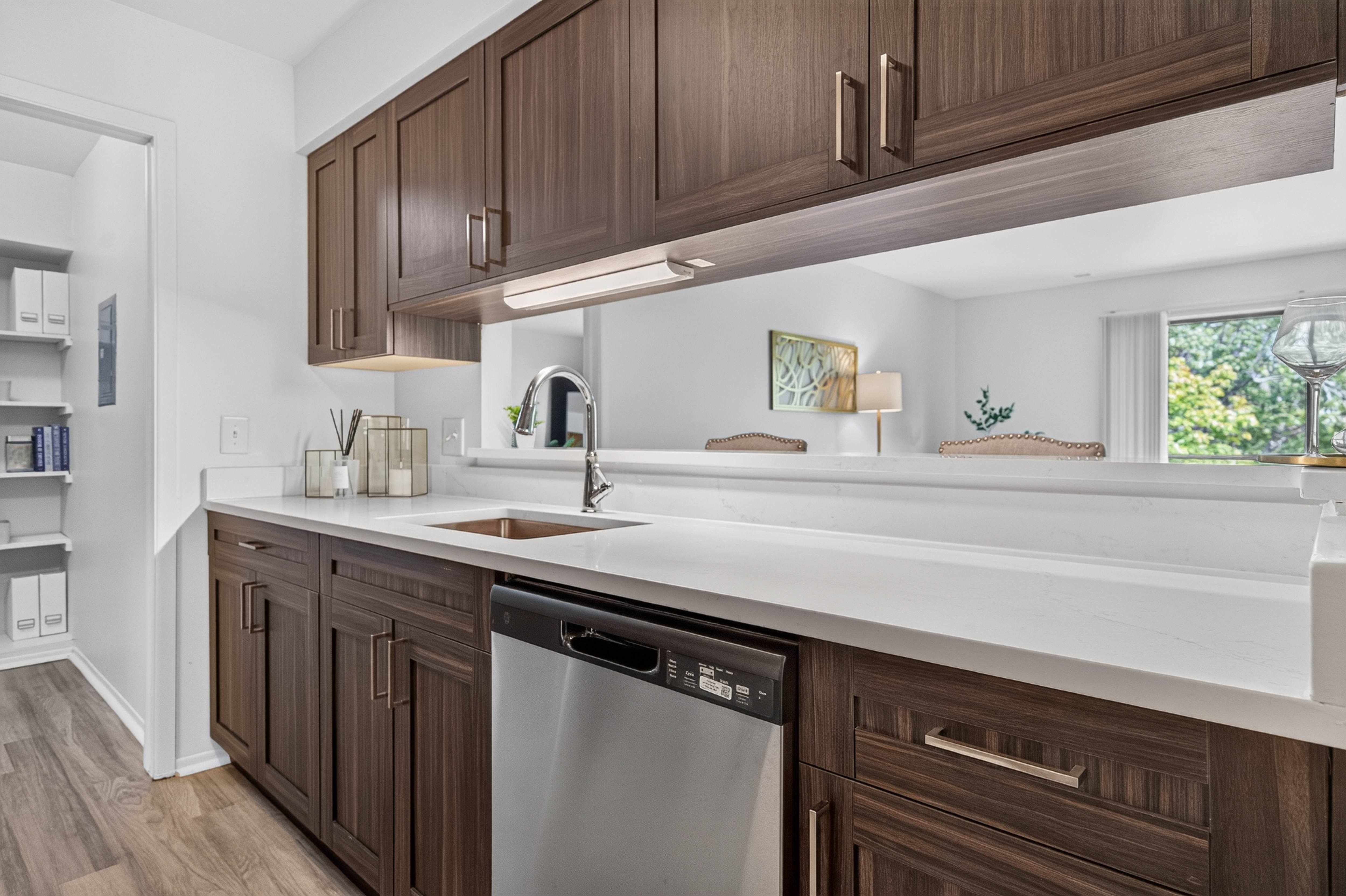 Modern kitchen with stainless steel appliances and pantry at Franklin River Apartments in Southfield, MI.