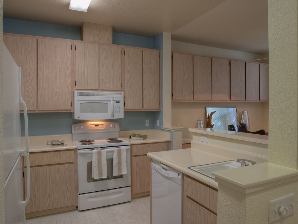 Classic Package I kitchen with light oak cabinetry, white laminate countertops, white appliances, and hard surface flooring
