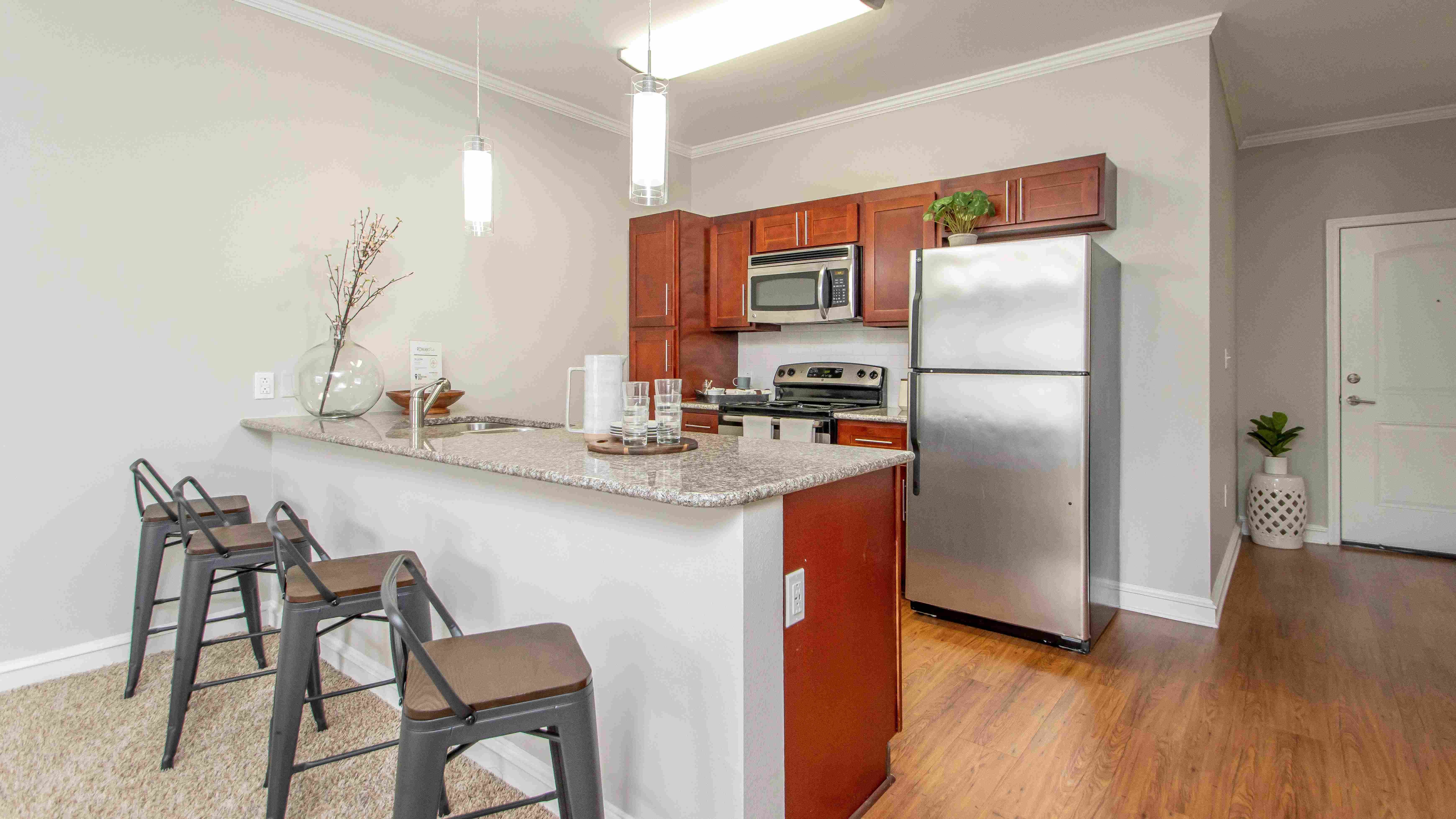 Feel joyous as you discover the elegance of our marvelous chef-inspired kitchens, adorned with captivating cherry wood cabinets and gourmet granite countertops, creating a charming space for whipping up culinary masterpieces. 