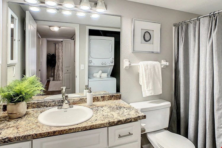 Pamper yourself in a spa-like oasis with white cabinets, granite-inspired countertops, and a relaxing garden.