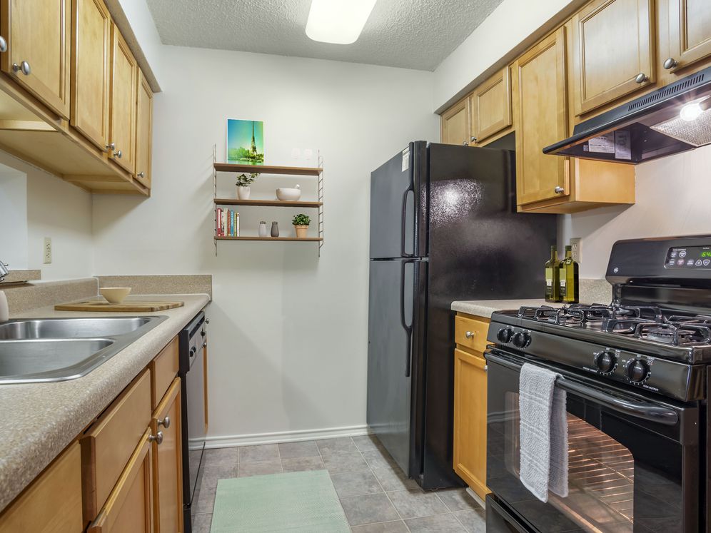 Classic Package kitchen with black appliances, laminate countertops, and tile flooring