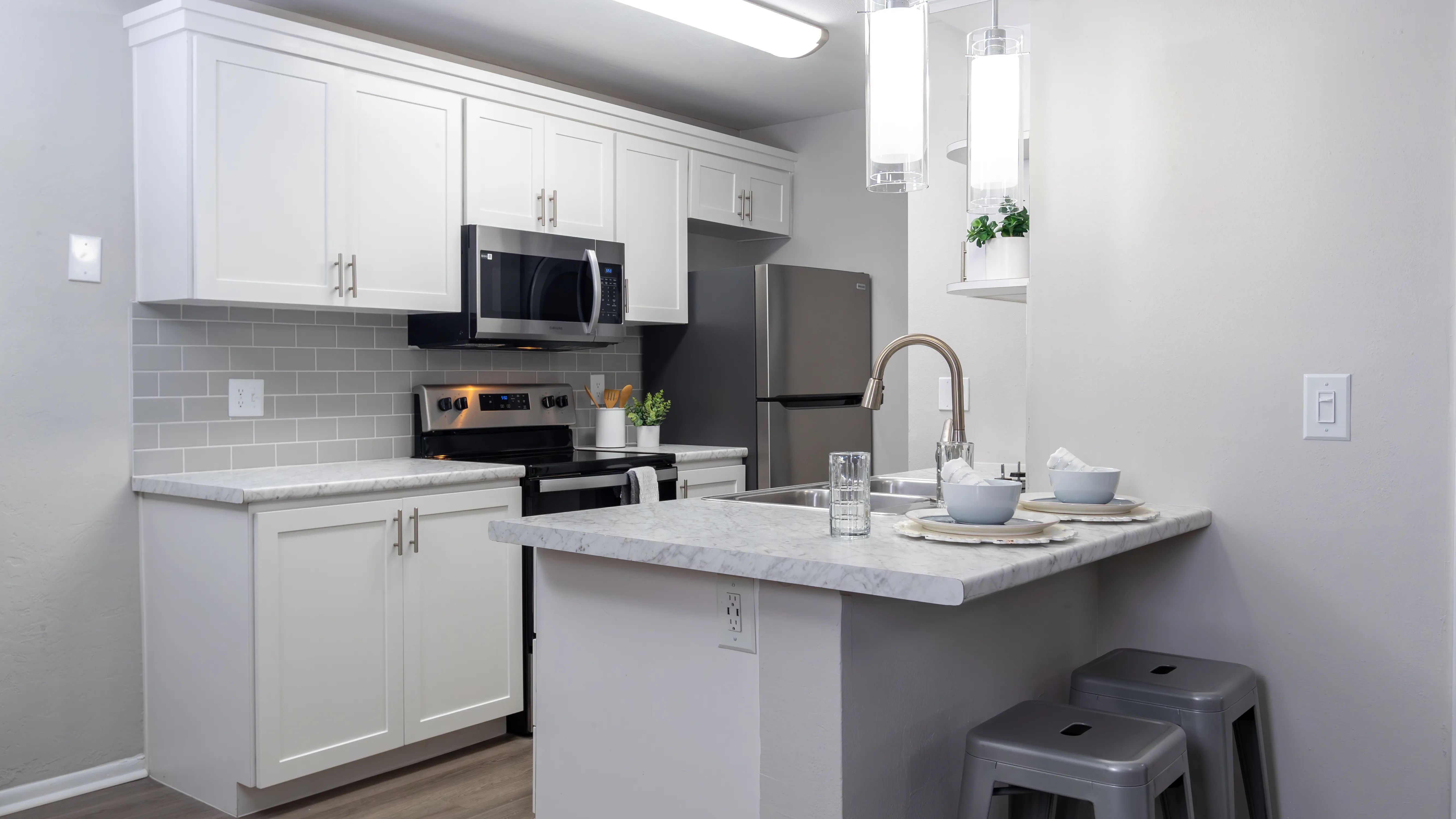 Bright kitchens adorned with gleaming stainless-steel appliances and marble-like countertops.