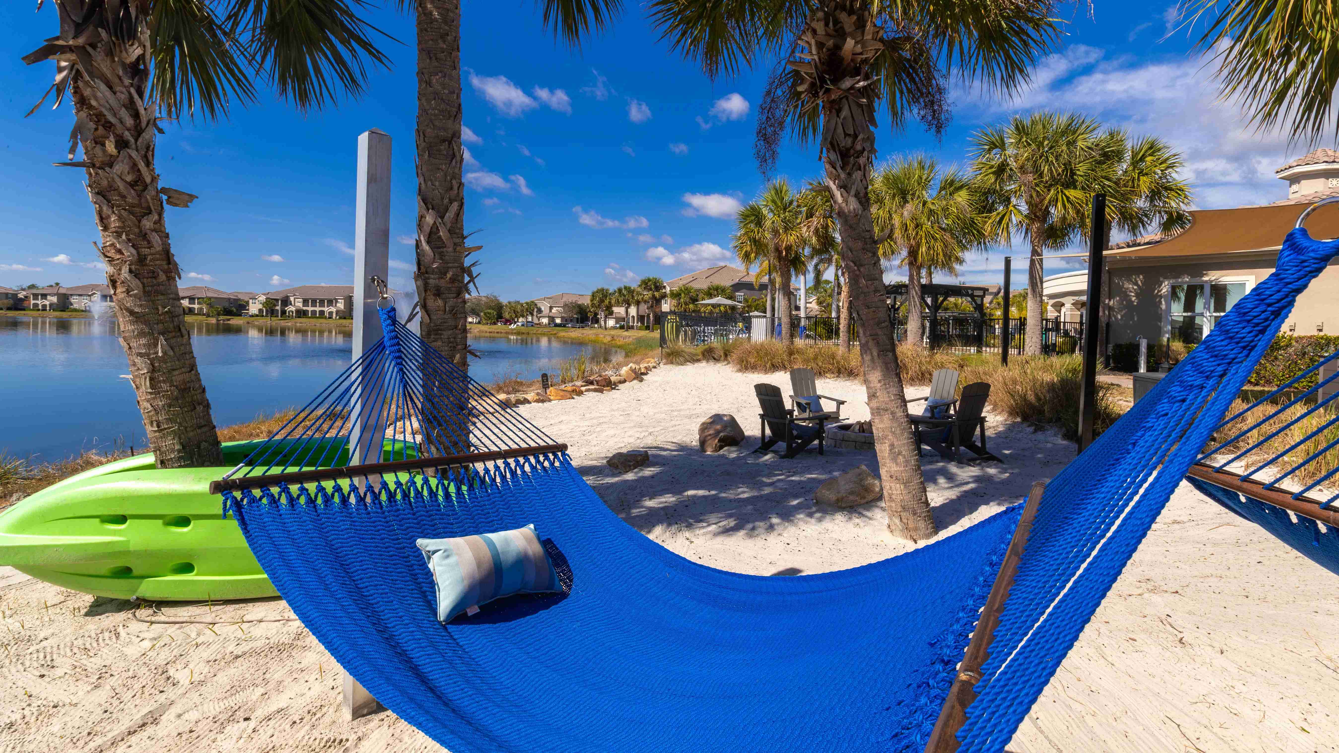 Enjoy ultimate relaxation with a shaded hammock, palm trees, and stunning lakeside scenery.