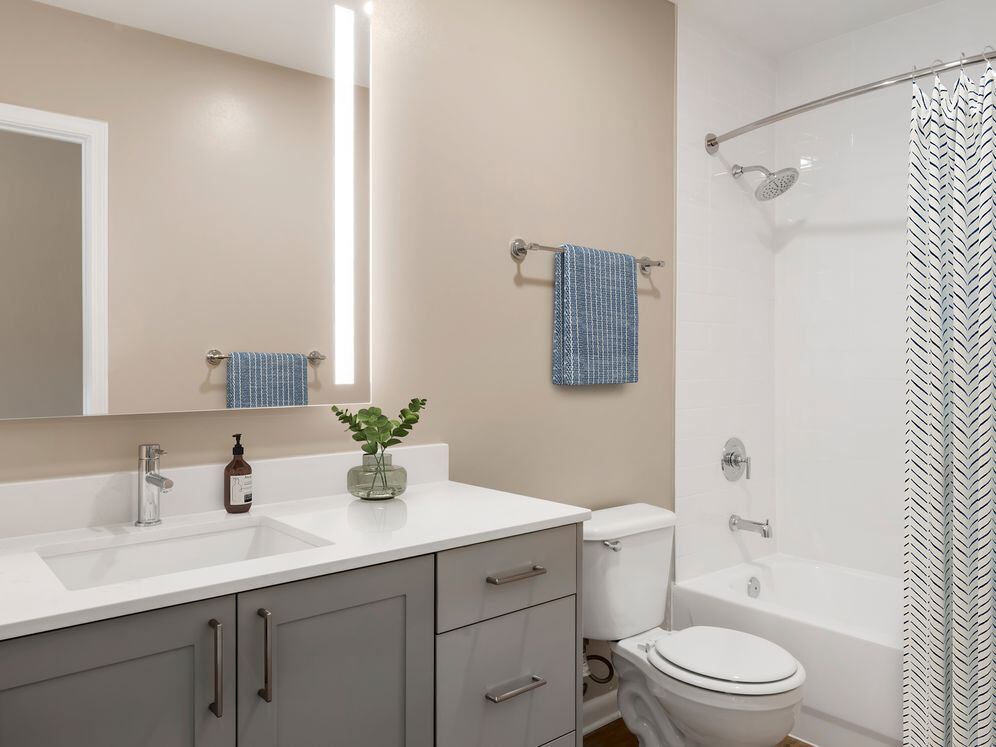 Signature Collection bath with grey cabinetry, white marbled quartz countertops, and hard surface flooring