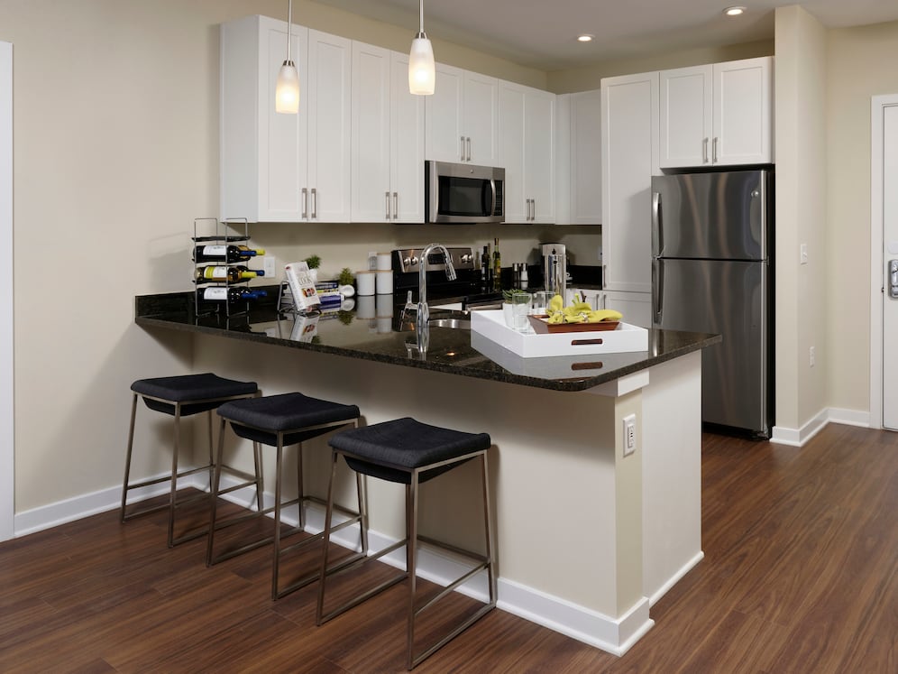 Hunt Valley - Finish Package I open concept kitchen and dining area with granite countertops, white shaker cabinetry, stainless steel appliances and hard surface flooring