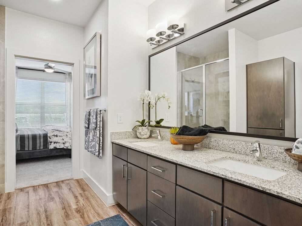 Bath with espresso cabinetry, speckled granite countertops, and hard surface flooring