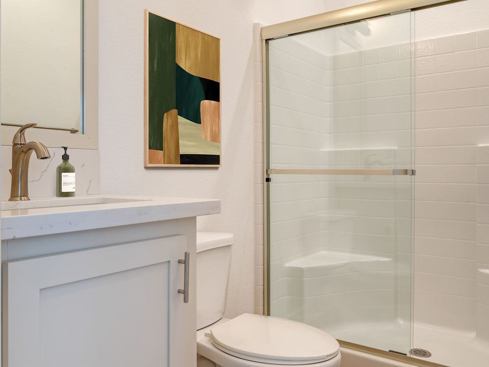Freestanding Home bath with white quartz countertops, white cabinetry, and hard surface flooring