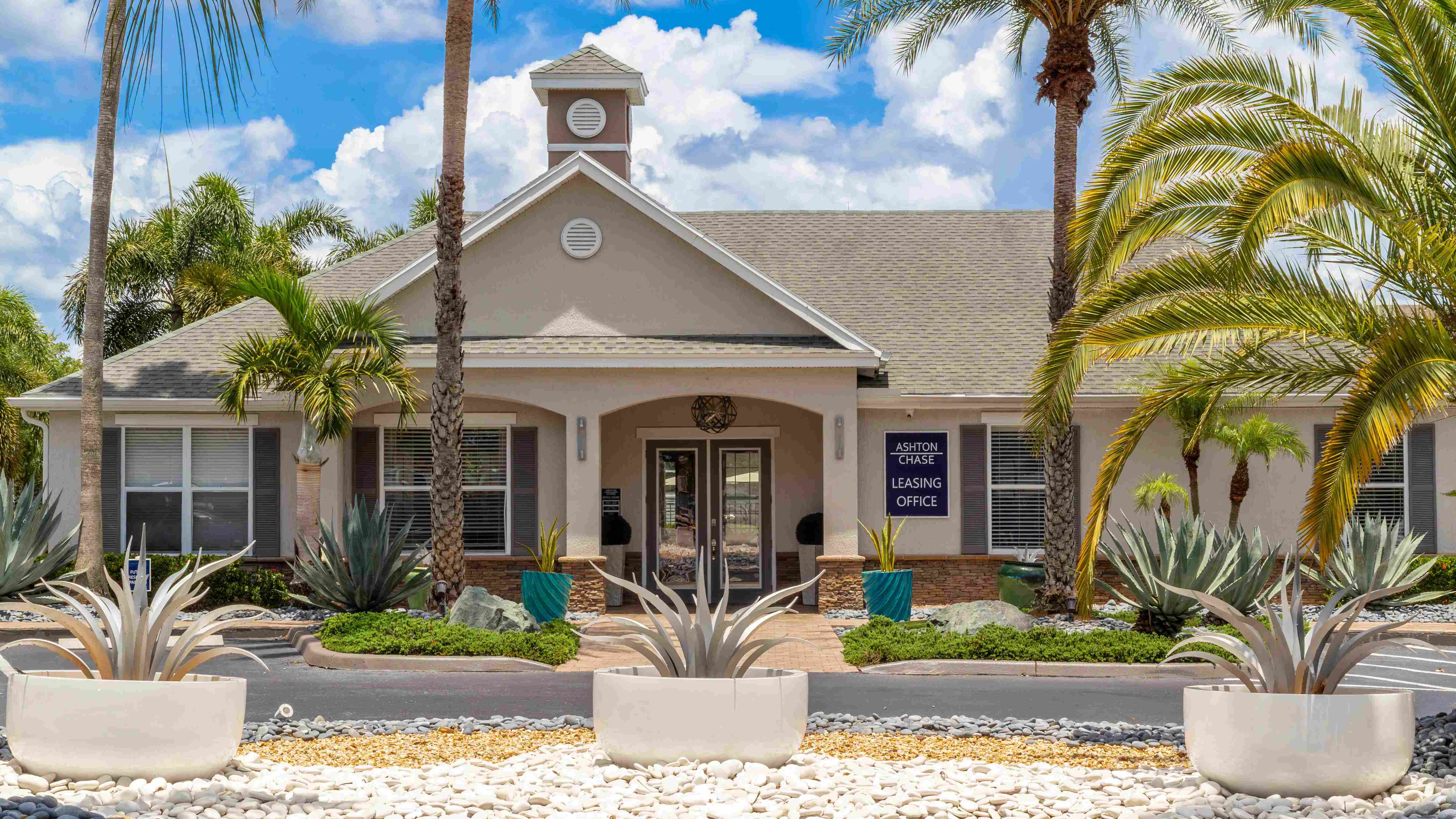 A warm welcome awaits at the Ashton Chase leasing office—surrounded by palm trees and designer landscaping that set the tone for resort-inspired living.