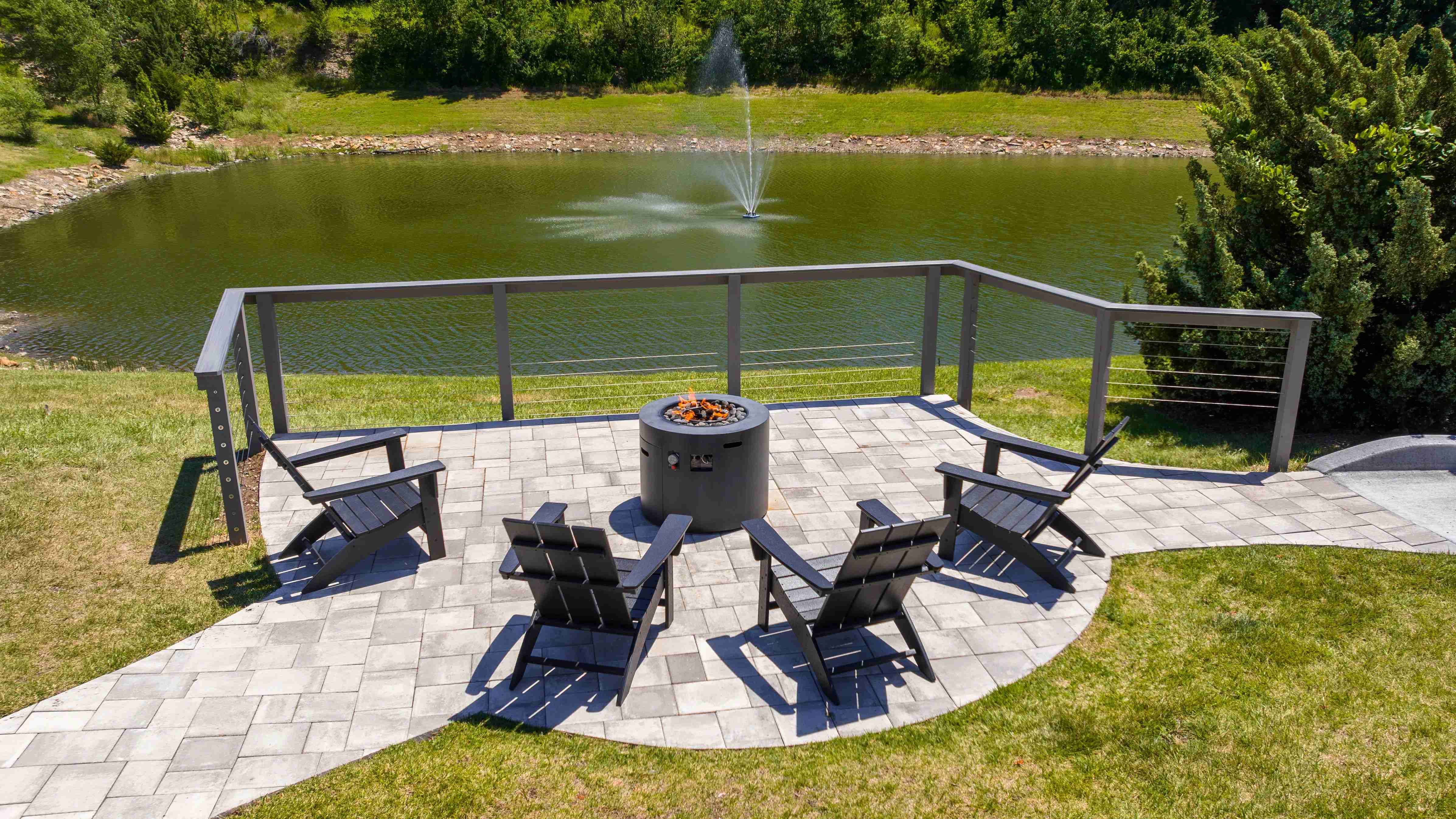 Relax by the fire pit with stunning views of the pond and fountain. Enjoy peaceful evenings with friends in this serene setting.