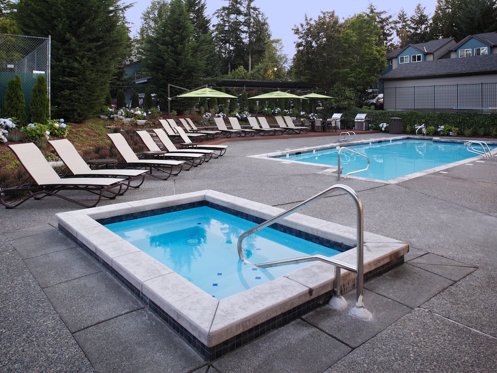 Outdoor spa and swimming pool with lounge seating