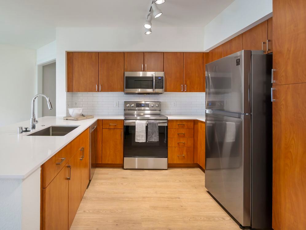 Newly renovated Finish Package II apartment homes feature kitchens with cherry cabinetry, white quartz countertops, stainless steel appliances, upgraded lightning, and hard surface flooring