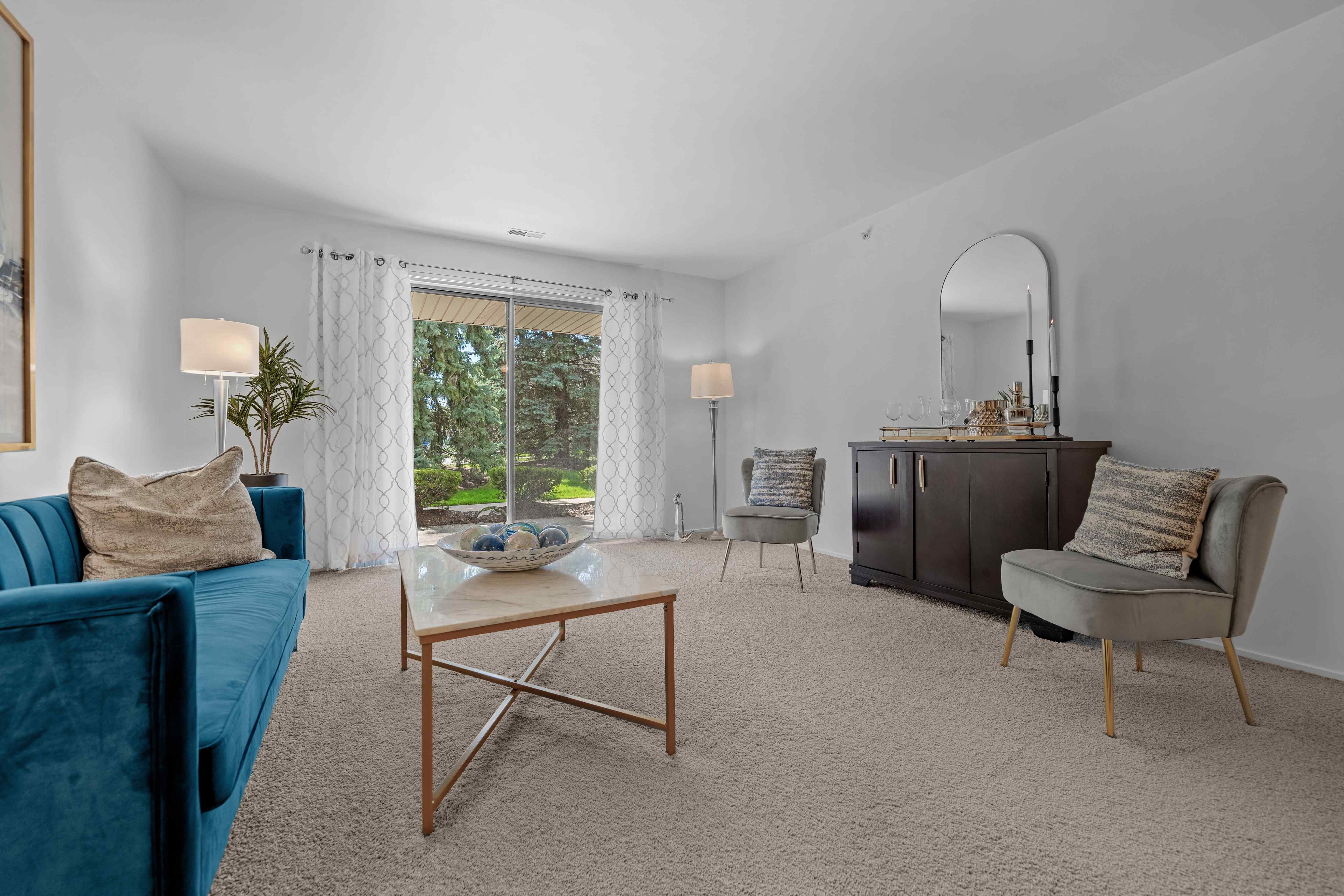Spacious Living room with patio at Prentiss Pointe Apartments in Harrison Township