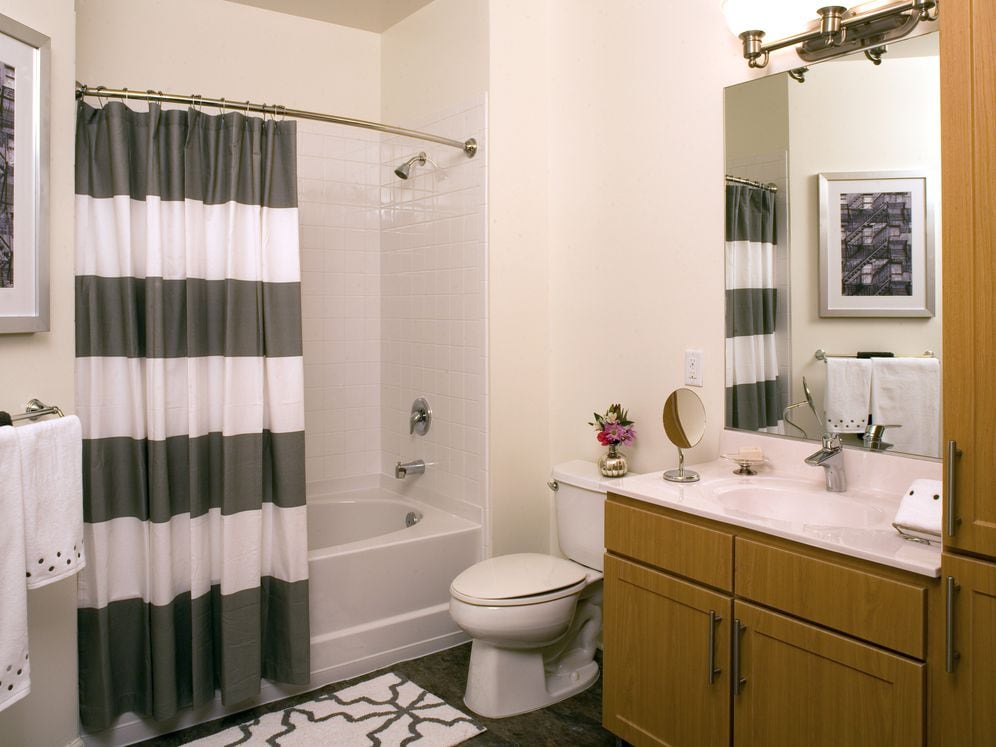 Classic Package bath with oak cabinetry, white quartz countertops, and hard surface flooring
