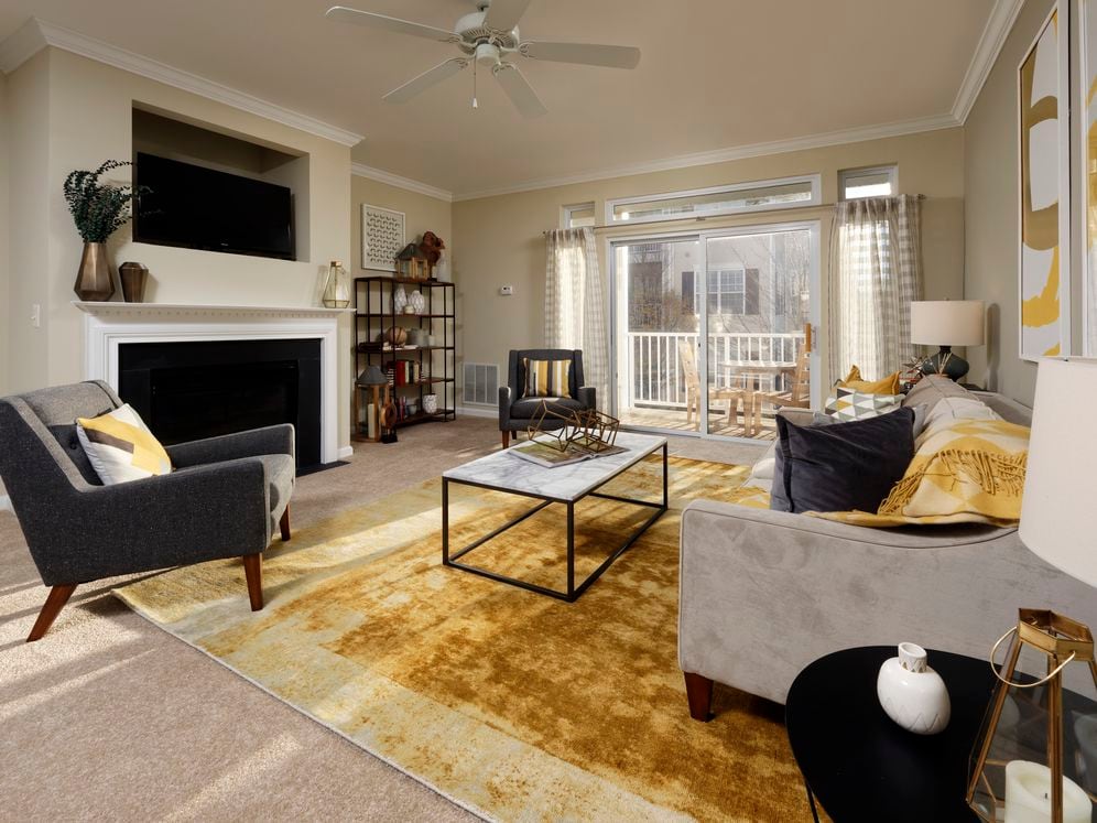 Classic Package I living area with fireplace, ceiling fan and carpeted flooring
