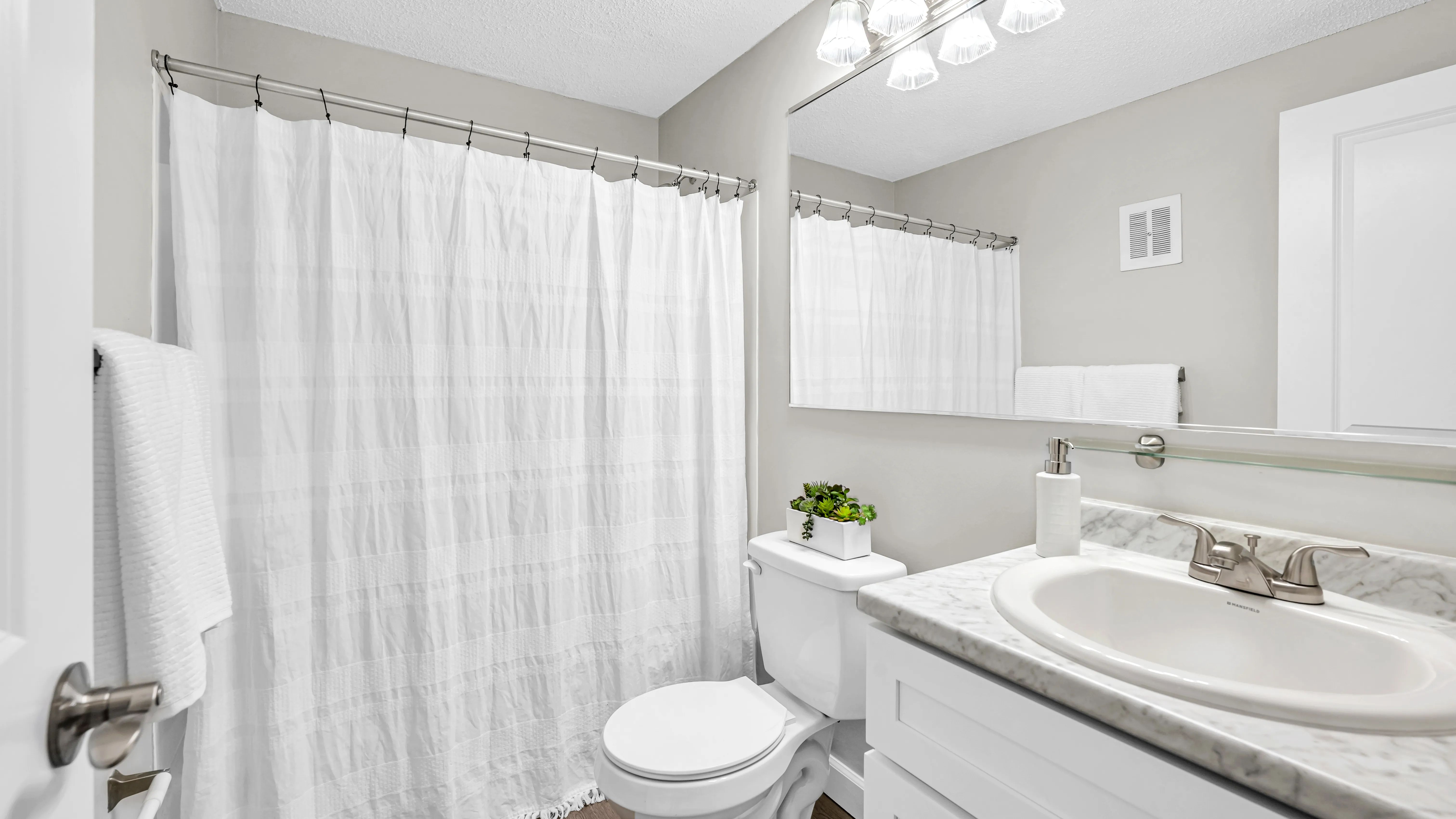 Step into elegant bathrooms featuring wood-style floors and marble-style countertops.