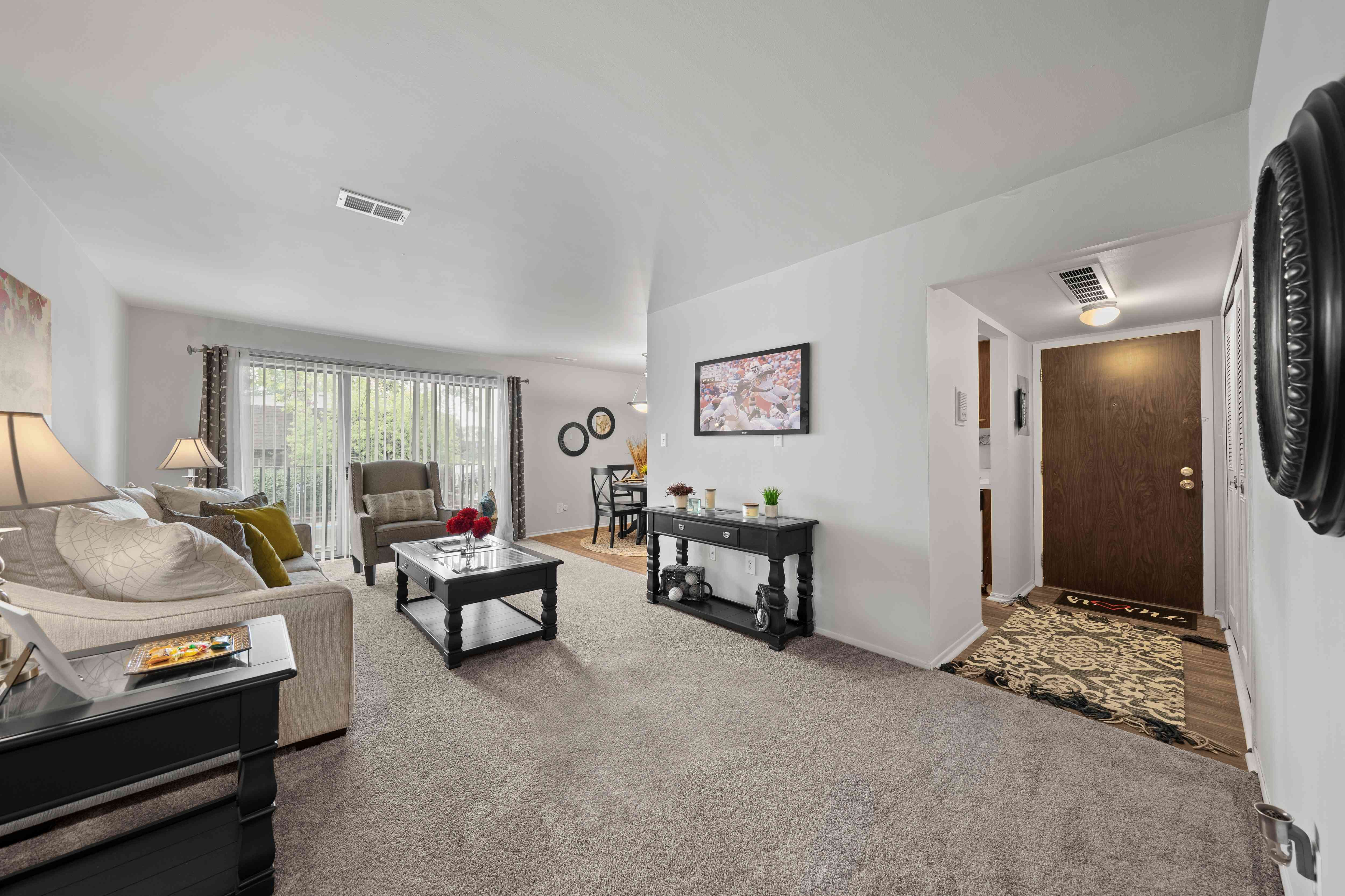 Open and airy living room with natural lighting at Knottingham Apartments in Clinton Township, MI.