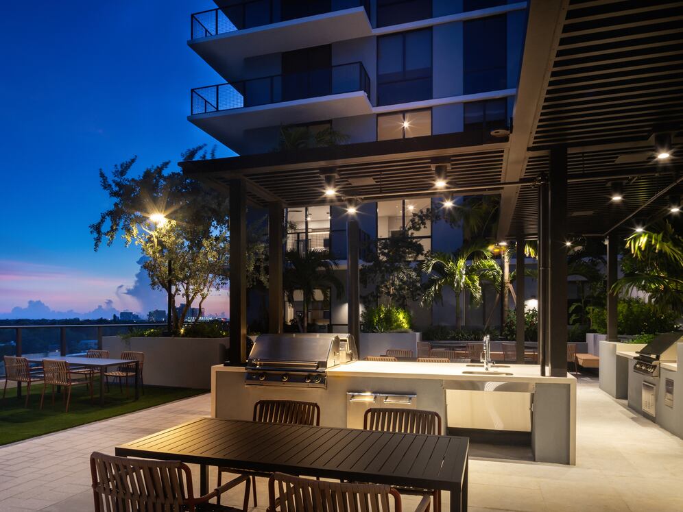 Outdoor lounge with BBQ grills and multiple seating areas