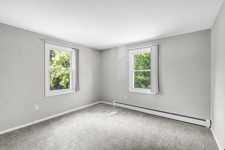 Spacious bedrooms with windows allowing natural sunlight to shine through.