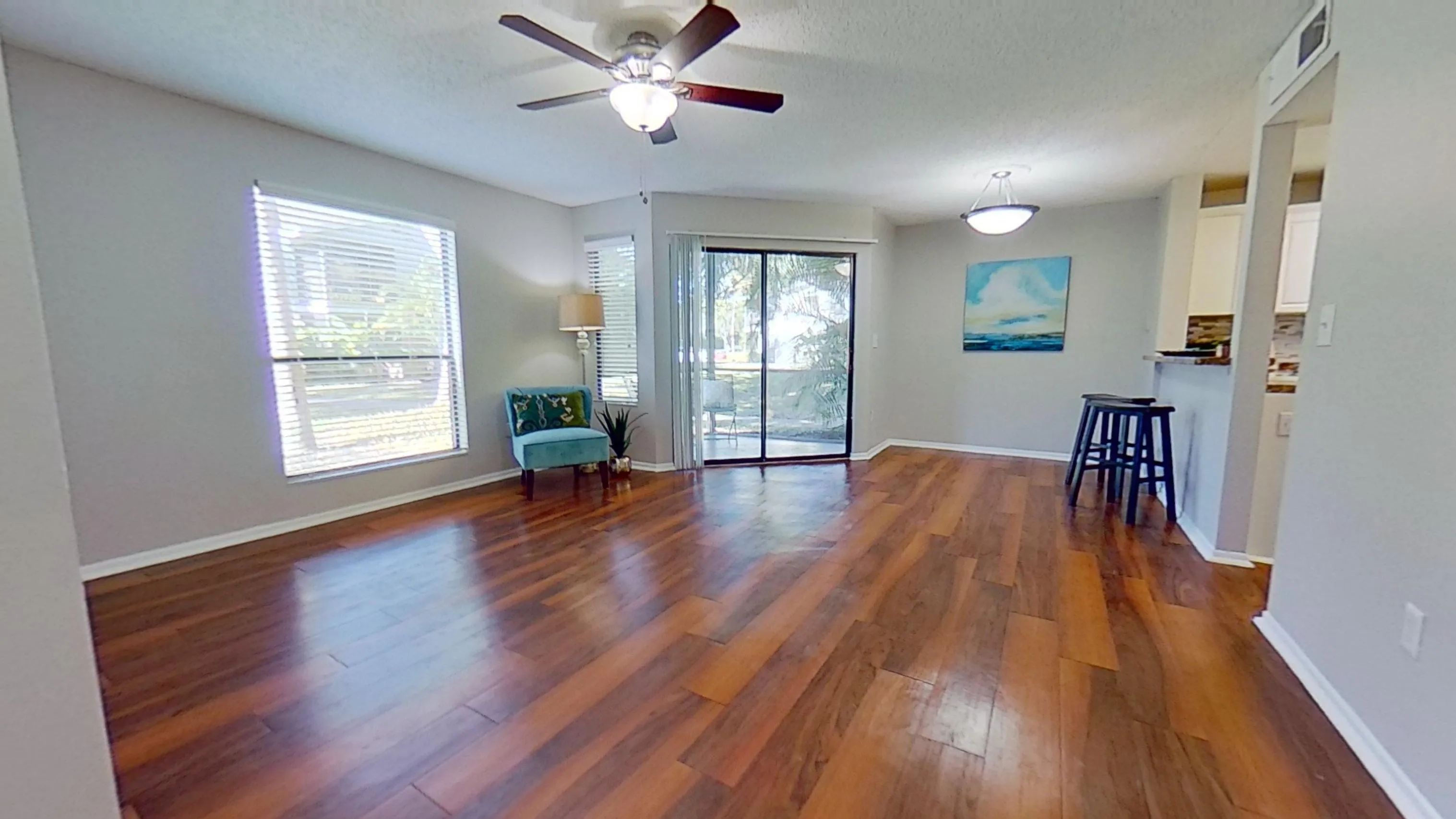 Experience a bright and open living space in The Newport Autograph floor plan. This living room offers plenty of natural light, wood-style flooring, and easy access to the private patio, perfect for relaxation and entertaining.